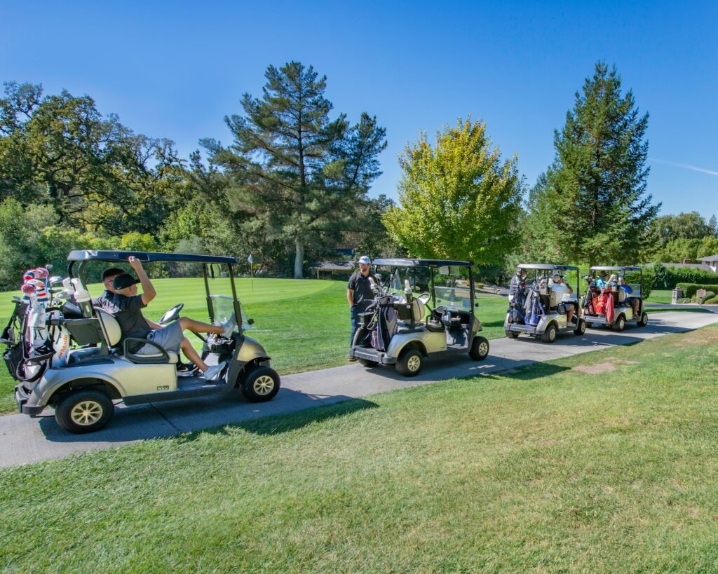 white golf cart on green grass field during daytime